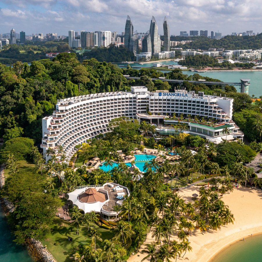 Exterior view of Shangri-La Rasa Sentosa and surrounding lush greenery by the beach on Sentosa island in Singapore.